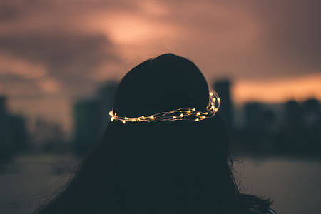 woman wearing white string light crown at night time thumbnail