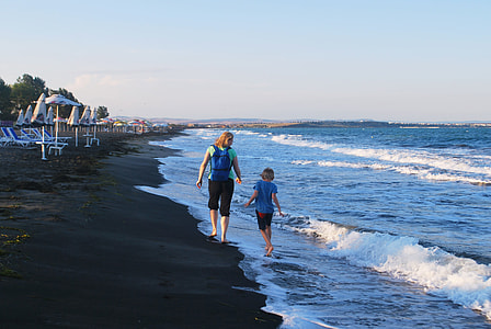 mother and daughter walking on seashore thumbnail