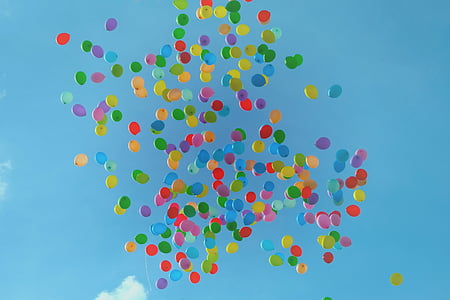 assorted-colored inflated latex balloons floating under blue sky thumbnail