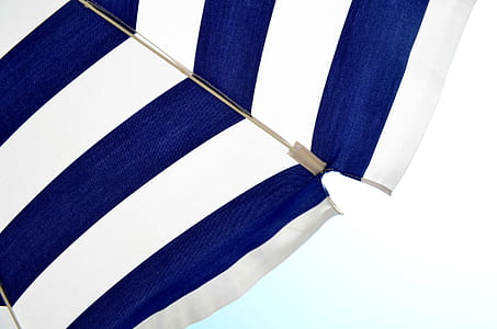 closeup photo of white and blue stripe beach umbrella thumbnail