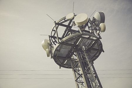 gray and white communication tower under cloudy sky thumbnail