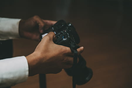 person holding black DSLR camera kit thumbnail