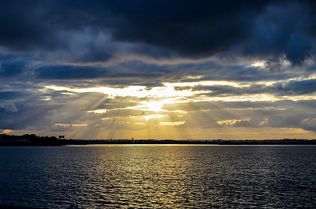 body of water under blue and yellow skies during sunset thumbnail