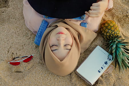 Woman Lying on Sand Beside Sunglasses thumbnail
