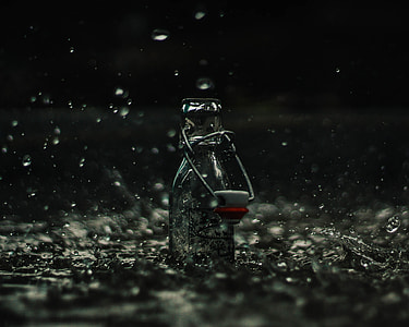 photo of clear glass bottle during rain thumbnail