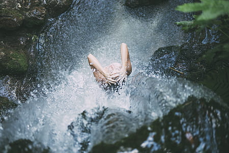 time laps photography woman standing in waterfalls thumbnail