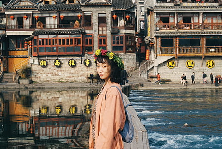 woman standing near body of water and buildings thumbnail
