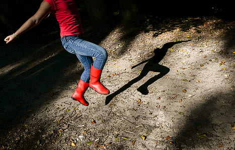 Photography of a Girl in Red Shirt With Blue Denim Jeans and Red Leather Wide-calf Boots Jumping thumbnail
