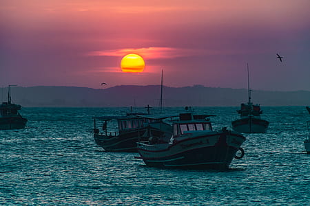 photography of motorboats on ocean water during sunset thumbnail