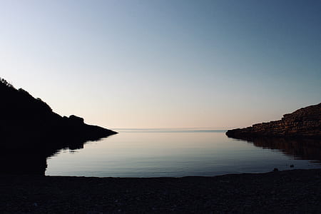 body of water beside mountains thumbnail