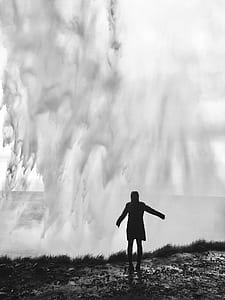 silhouette of person standing near crushing ocean waves thumbnail