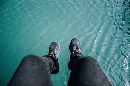 person wearing black denim jeans and pair of gray-and-black lace-up shoes thumbnail