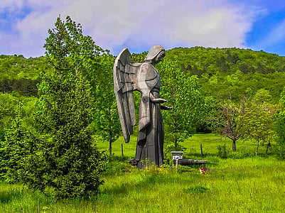 angel statue on plain grass field at daytime thumbnail