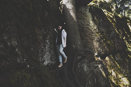 boy wearing gray cardigan on brown rock formation during daytime thumbnail
