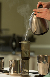 person pouring hot water on gray glass bottle thumbnail
