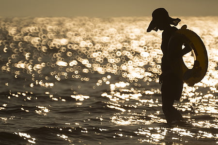 woman on body of water during sunset thumbnail