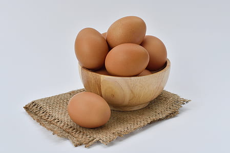 Brown Eggs on Brown Wooden Bowl on Beige Knit Textile thumbnail