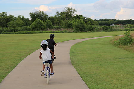 boy and girl riding bicycles during daytime thumbnail