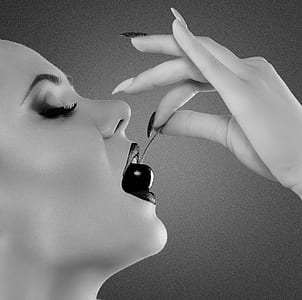 grayscale photo of woman eating berry thumbnail