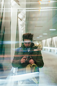 man wearing brown jacket while camera thumbnail