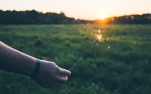 person holding sparkler during sunset thumbnail
