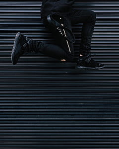 person jumping beside black steel gate thumbnail