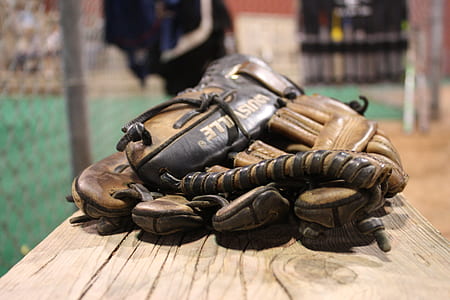 selective focus photography of baseball mitt on brown board thumbnail