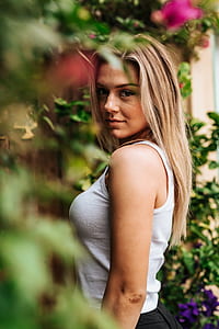 selective focus photography of woman standing under green leaf tree thumbnail