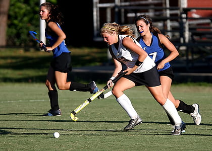 three women playing field hockey thumbnail