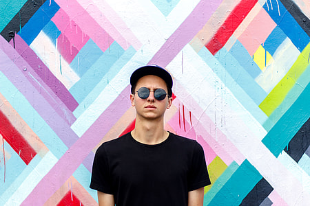 man wearing black crew-neck t-shirt with multicolored background thumbnail