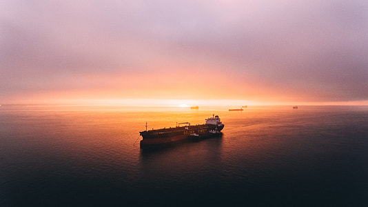 white and brown boat on body of water during sunset thumbnail