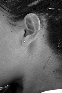 grayscale and close-up photo of person wearing stud earring thumbnail