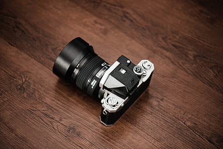 black and gray DSLR camera on brown wooden surface thumbnail