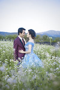 man and woman face each other in the middle of flower field at daytime thumbnail