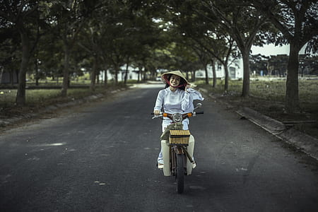 woman riding motor scooter during daytime thumbnail