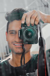 Man Holding Black Canon Eos thumbnail