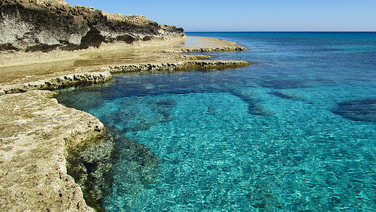 rock formations near calm sea water at daytime thumbnail