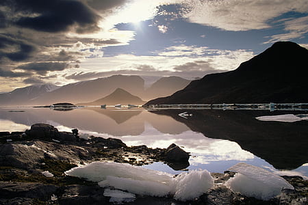mountain surrounded by body of water thumbnail