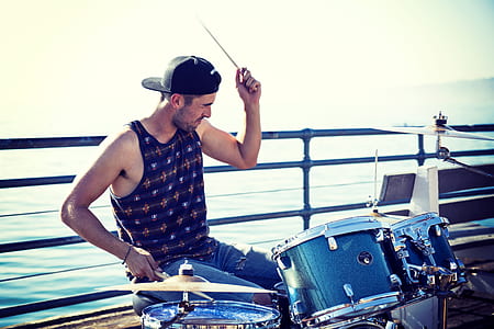 man wearing black tank top holding drumstick thumbnail