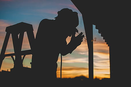 silhouette of man welding on steel house pillar thumbnail