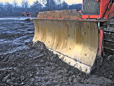 red and brown plow on black soil during daytime thumbnail