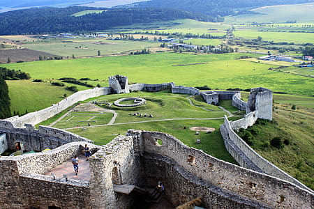 people walking in concrete ruins near open field at daytime thumbnail