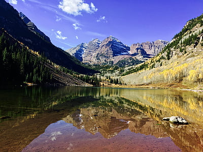 landscape photography of body of water surrounded of mountains thumbnail
