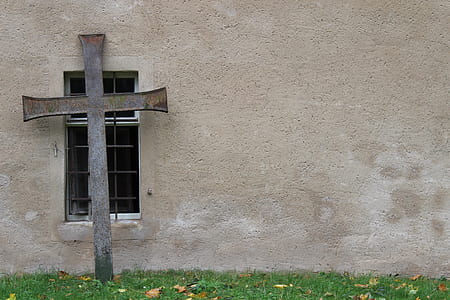 gray steel cross leaning on gray concrete wall thumbnail