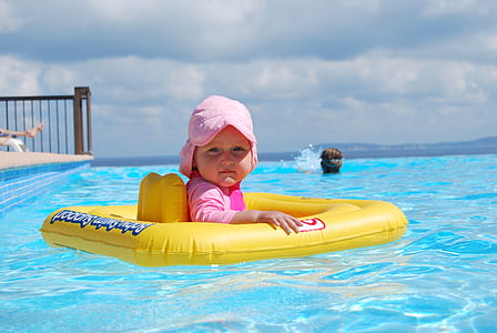 baby riding on yellow floater on body of water at daytime thumbnail