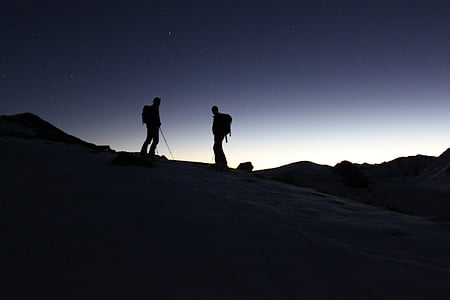 silhouette photo of two hikers on mountain during nighttime thumbnail