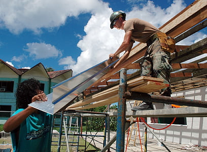 carpenter holding silver metal sheet thumbnail