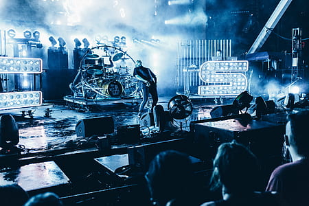 man standing on stage bending backward digital wallpaper thumbnail