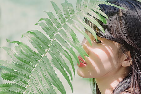 Close-Up Photography of Woman Near Fern thumbnail