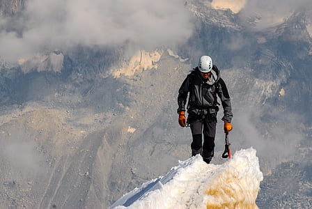man wearing jacket walking on mountain covered in ice thumbnail